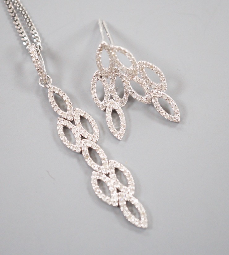 A modern 18ct white gold and diamond chip set septuple oval cluster pendant, overall 42mm, on an 18ct white gold fine link chain, 39cm and a pair of matching earrings, 21mm, gross weight 7.4 grams.